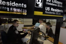 Oficial de Aduanas y Protección Fronteriza revisa documentación de viajeros en un aeropuerto